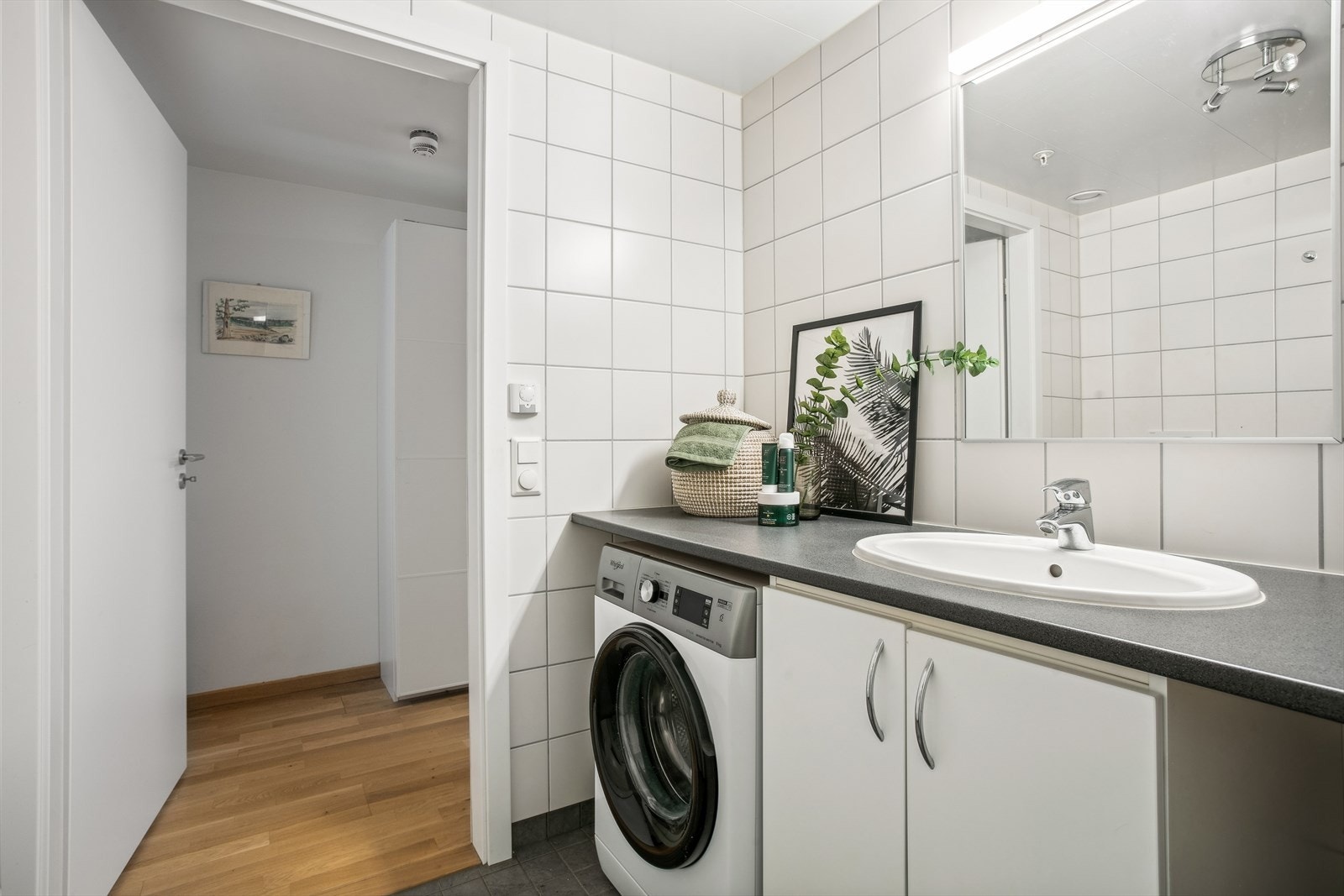 Tidløst, helfliset baderom fra 2018 med downlights i himlingen. Rommet er utstyrt med baderomsinnredning, dusjhjørne og vegghengt toalett. Galleribilde
