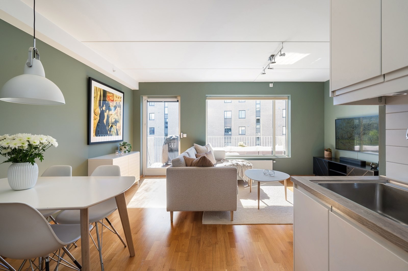 Store vinduer i stuen gir fint med naturlig sollys inn til dette sosiale allrommet. Galleribilde