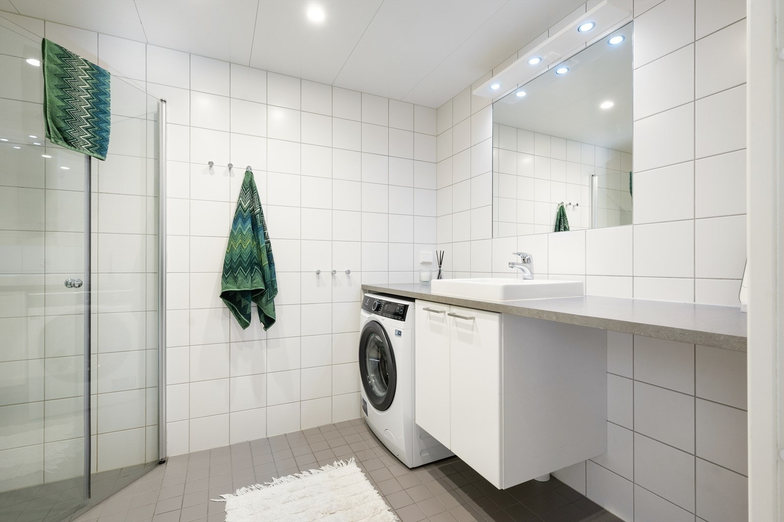 Moderne flislagt bad med varmekabel i gulv og downlights i himling. Galleribilde