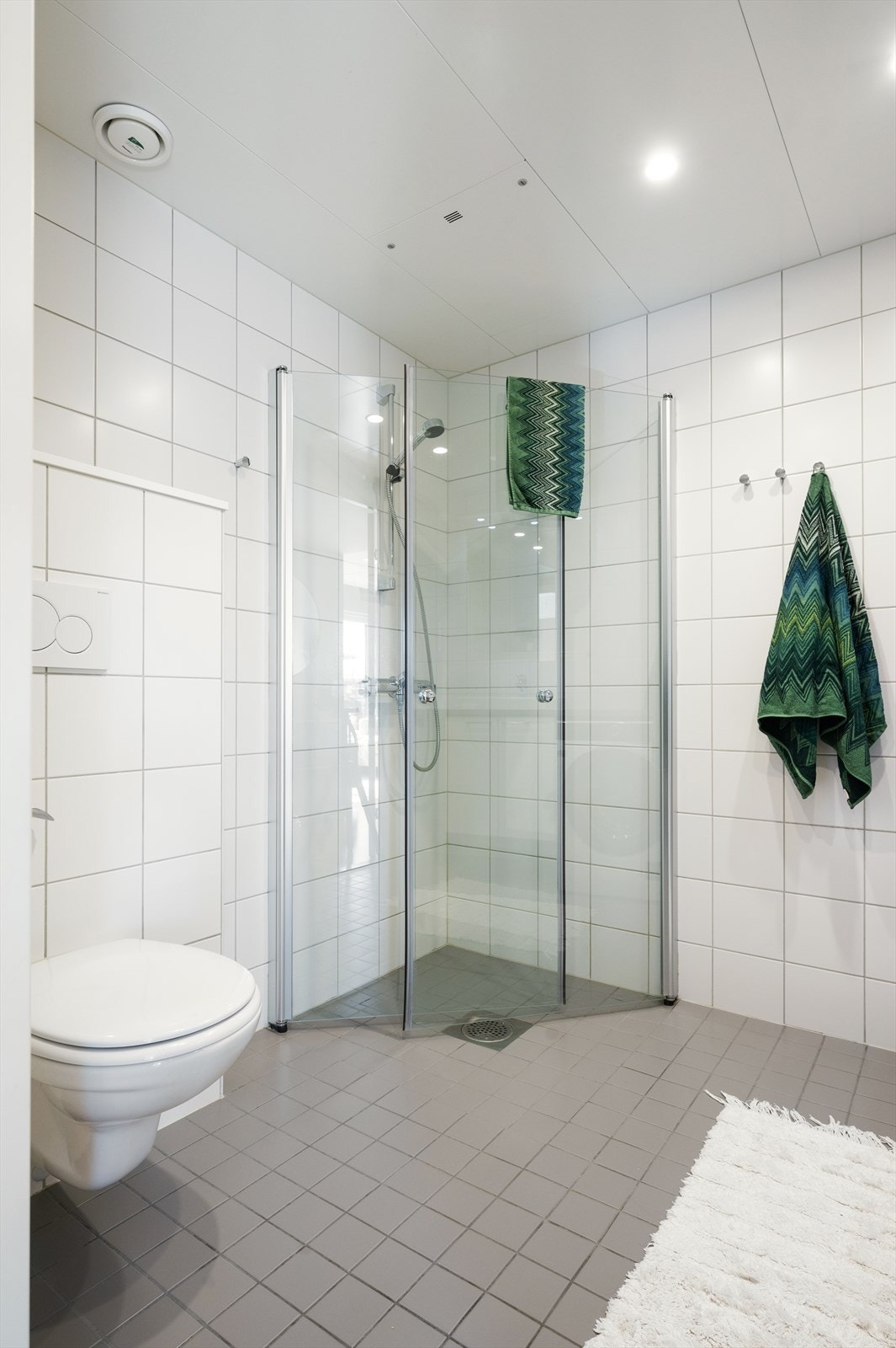 Vegghengt wc og dusjhjørne med innfellbare glassdører. Galleribilde