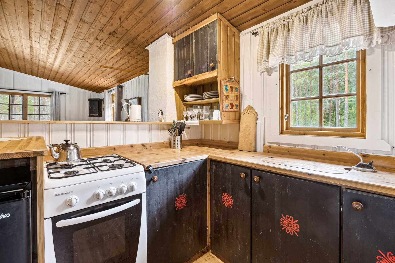 Kjøkkenet har malt heltre innredning med glatte fronter. Innredningen består av underskap i vinkel med heltre benkeplate. Det er en delevegg mellom kjøkkenet og stuen, som gjør at stuen og kjøkkenet er ett felles rom. Galleribilde