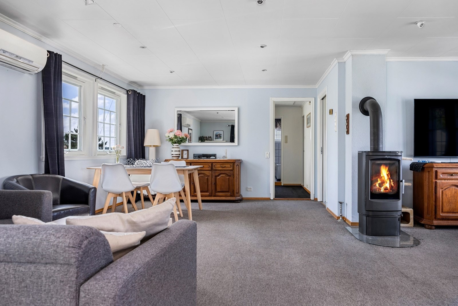 Romslig stue med plass til flere sittegrupper og spisebord, samt utgang til skjermet og solrik terrasse. Galleribilde
