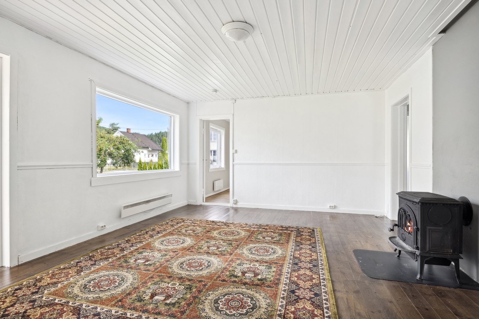 Stuen i første etasje fremstår lys og luftig med gode vindusflater som gir rikelig med naturlig lys til rommet. Her er det god plass til å møblere med både sofagruppe og spisebord om ønskelig. Peisovnen søger for godt med varme på kalde dager. Fra stuen e Galleribilde