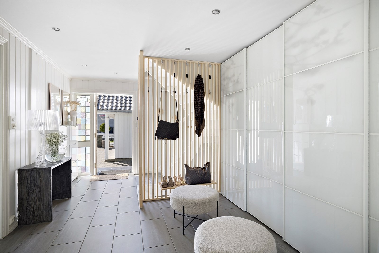 Entré og hall med god oppbevaringsplass i skyvedørsgarderobe - fliser med varme i gulv Galleribilde