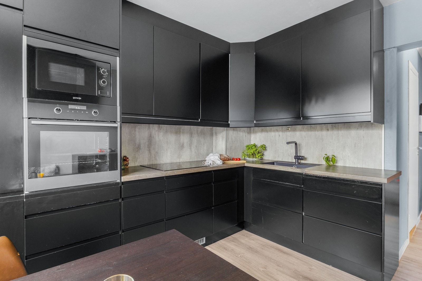 Kjøkkenet har glatte fronter, laminat benkeplate med nedfelt vaskekum, samt splashboard og belysning over benkeplaten. Galleribilde