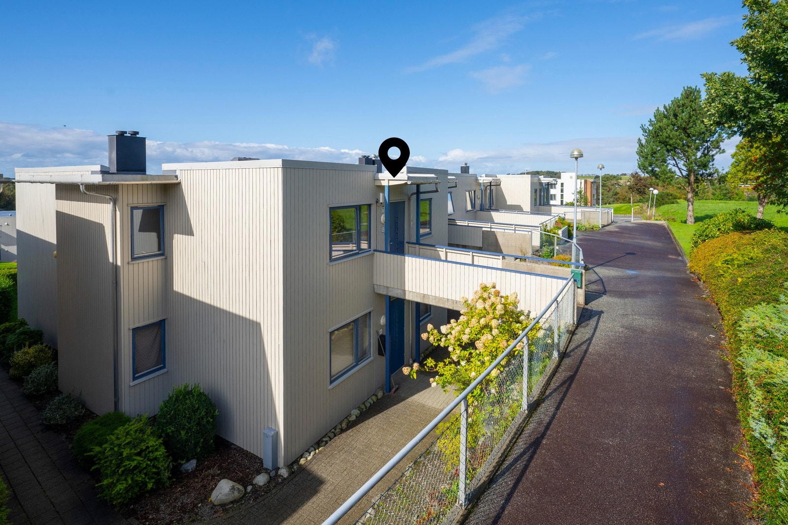 Inngang fra bakkeplan gjør at dette både kalles og oppleves som en rekkehusleilighet. Galleribilde