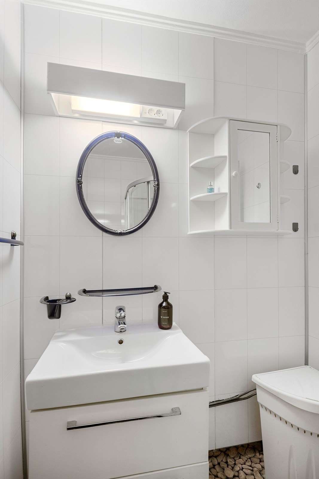 Badet er utstyrt med servant, skapinnredning, speil, lysarmatur og dusjkabinett. Galleribilde