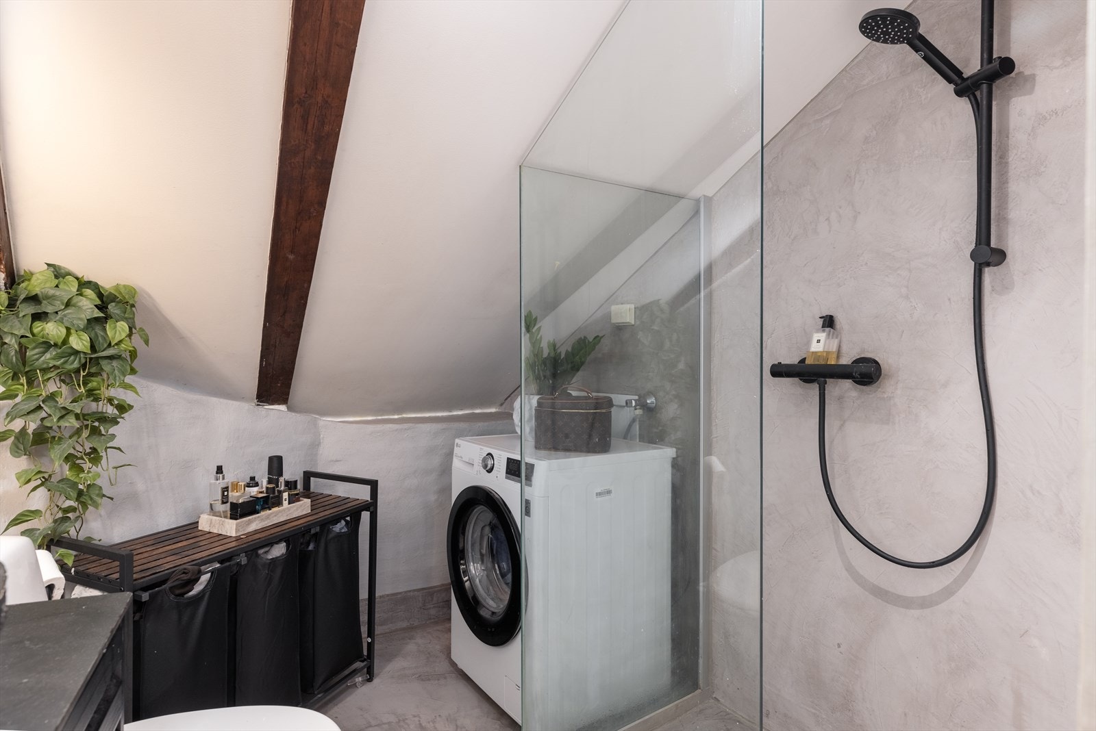 Innredningen består av gulvmontert toalett, 80 cm. servant med benkeplate og underskuffer, speil, og dusjhjørne med glassvegger. I hjørne er det opplegg for vaskemaskin. Galleribilde