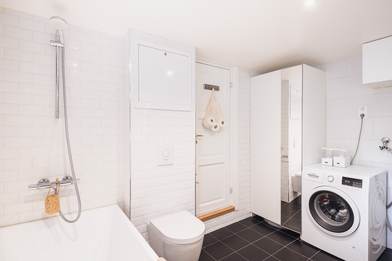 Badet i kjelleren har gulvvarme, flislagte overflater, ekstra skapplass og opplegg for vaskemaskin. Galleribilde