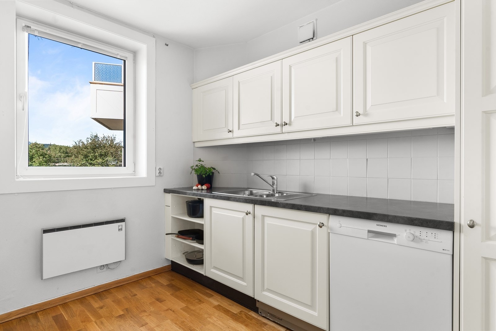 Det er opplegg for vaskemaskin i kjøkkenskapet. Galleribilde