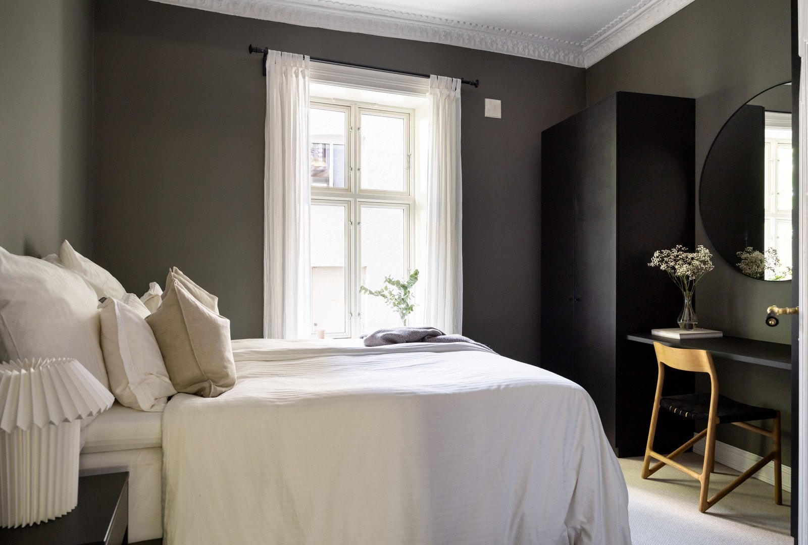 Rommet oppleves med en avslappet atmosfære med mørke vegger og naturlig lysinnslipp fra vinduet. Galleribilde