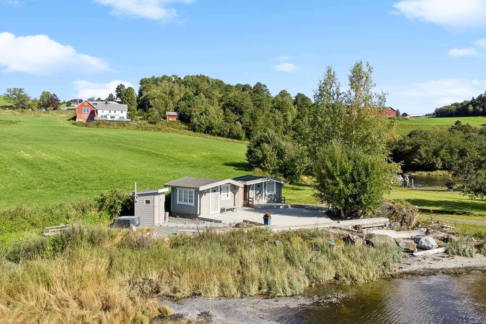Nede ved sjøkanten har eiendommen flere holdeplasser for trivsel. Med campinghytter, strand, molo og flotte grøntområder. Galleribilde