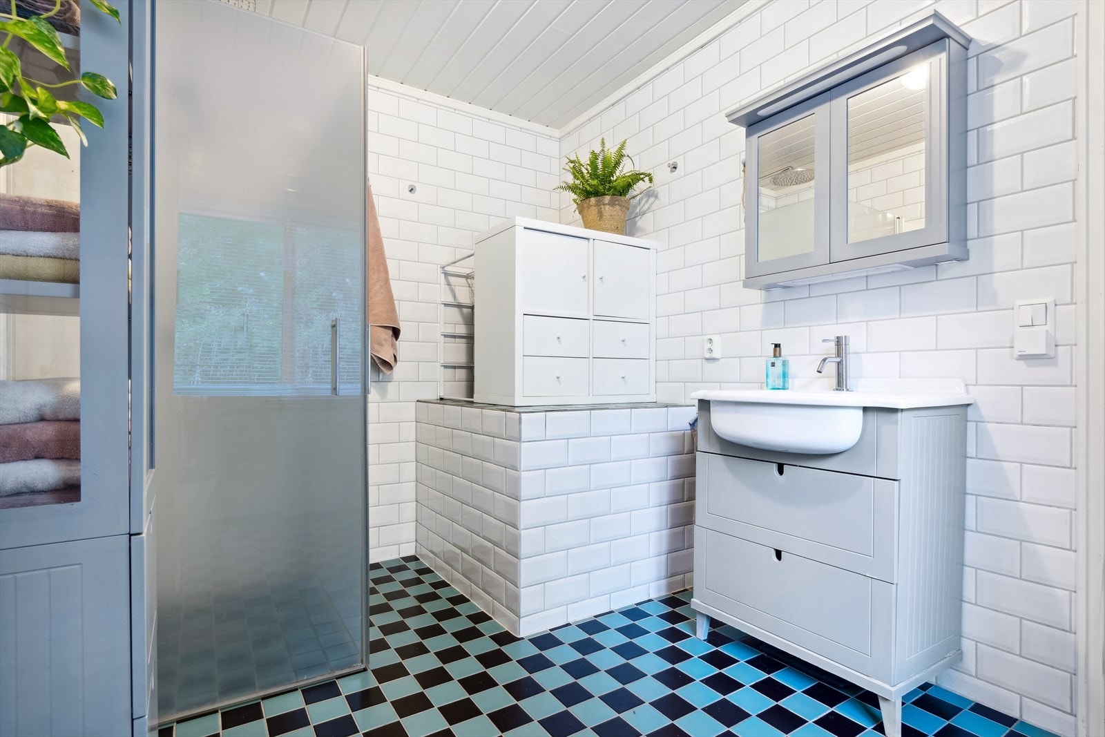 Fint flislagt bad med lys stilfull baderomsinnredning, dusjnisje og toalett. Galleribilde