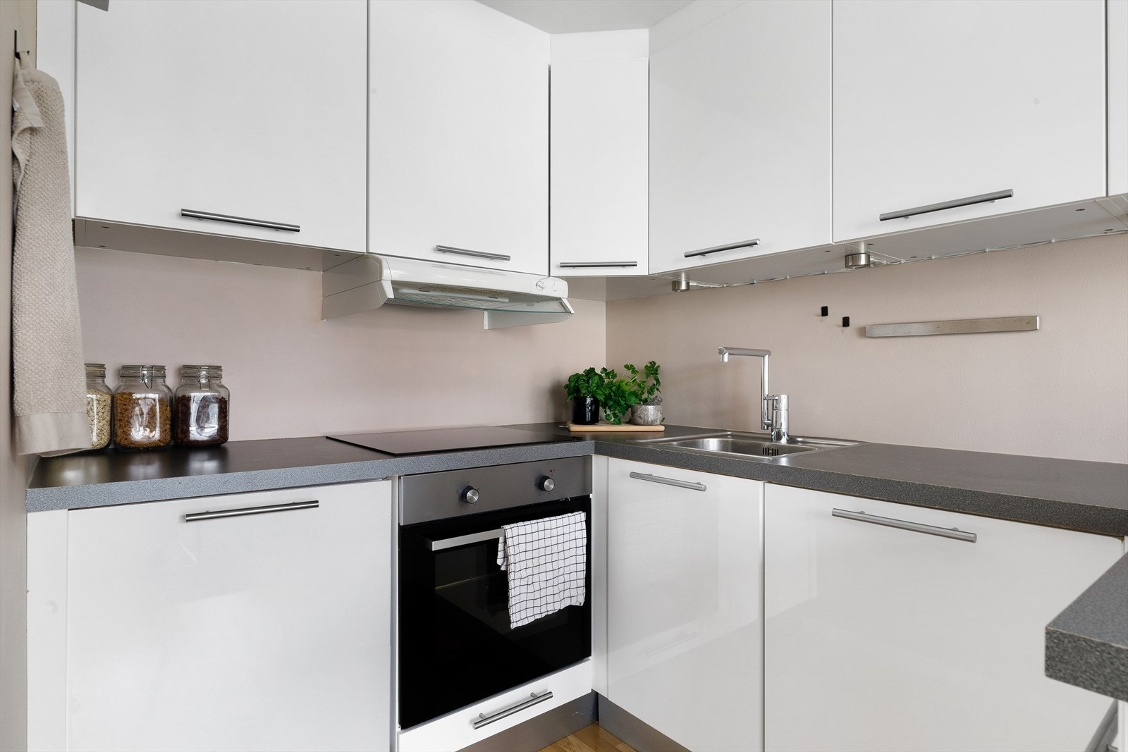 Kjøkkeninnredningen har en tidløs utførelse med hvite, slette fronter og benkeplate av laminat Galleribilde