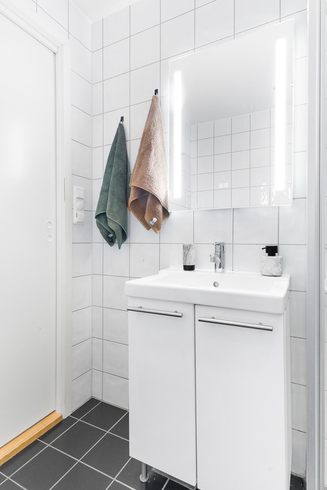 Det er utstyrt med servant i baderomsmøbel, vegghengt toalett, dusjhjørne med glassdører Galleribilde