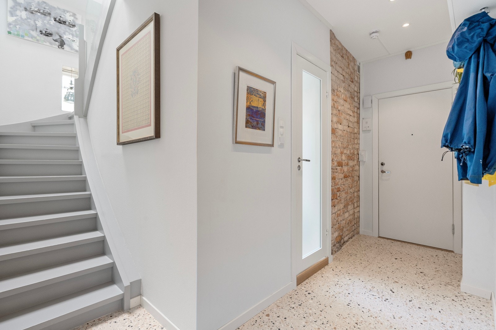 Innbydende og romslig entré med slitesterkt, flislagt gulv og gulvvarme. Original teglsteinsvegg skaper en stemningsfull atmosfære. Galleribilde