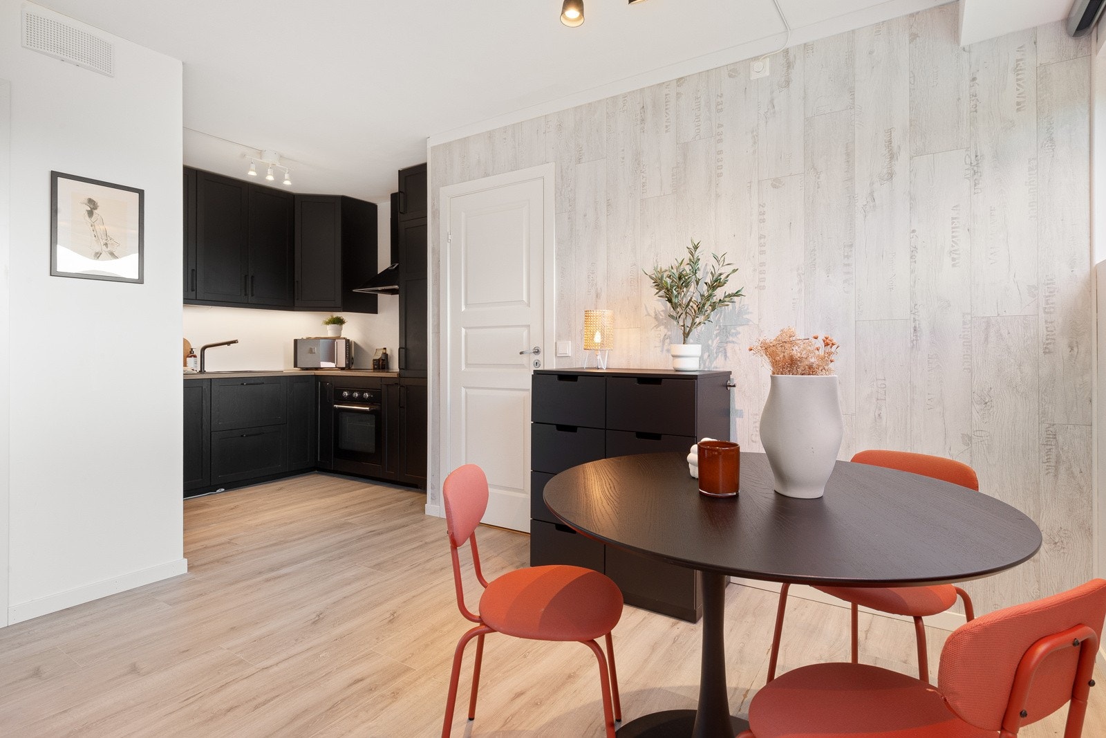 Nyere, moderne og sortbeiset Ikea kjøkken (2019) med tilhørende hvitevarer. Kjøkkenet er plassert i en nisje og er således noe avskjermet fra stuen. En god løsning! Galleribilde