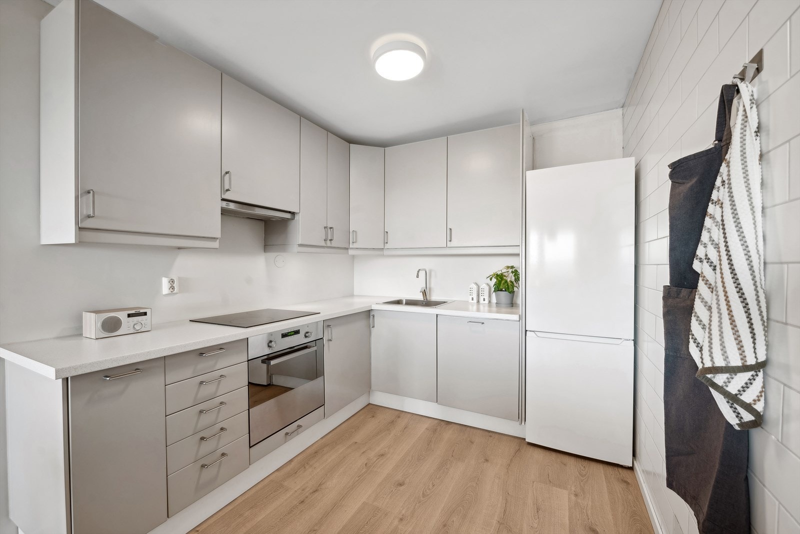 Kjøkkenet har en tidløs Ikea-innredning av noe eldre dato med glatte malte fronter. Laminat benkeplate. Galleribilde