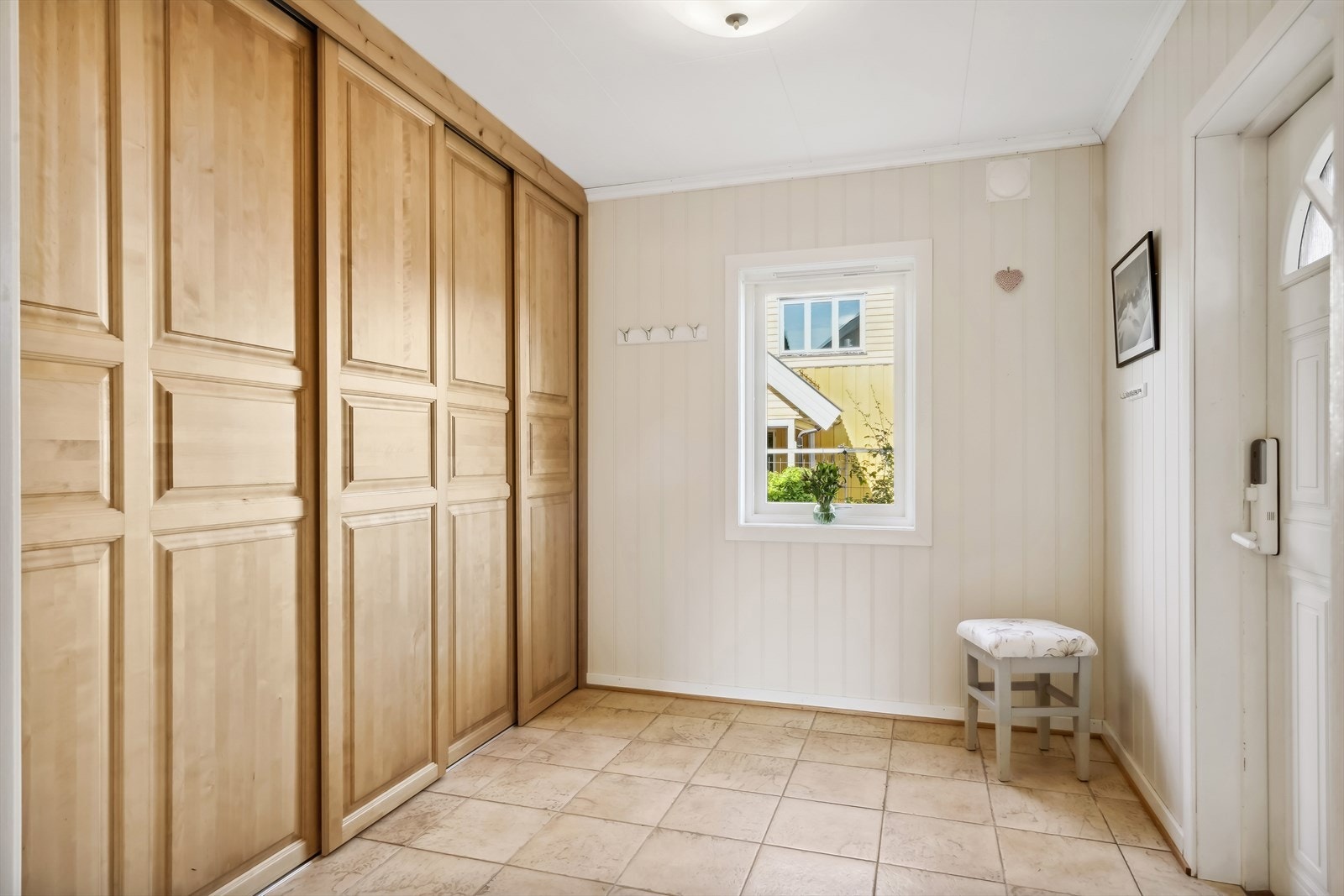 Velkommen inn til denne romslige og lyse entréen! Her finner du en skyvedørsgarderobe som gir rikelig med oppbevaringsplass Galleribilde
