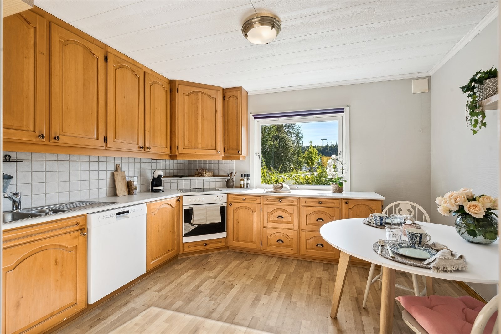 Et romslig kjøkken med rikelig benk- og skapplass. Kjøkkenet har et frittstående kjøleskap, halvintegrert oppvaskmaskin og komfyr... Galleribilde