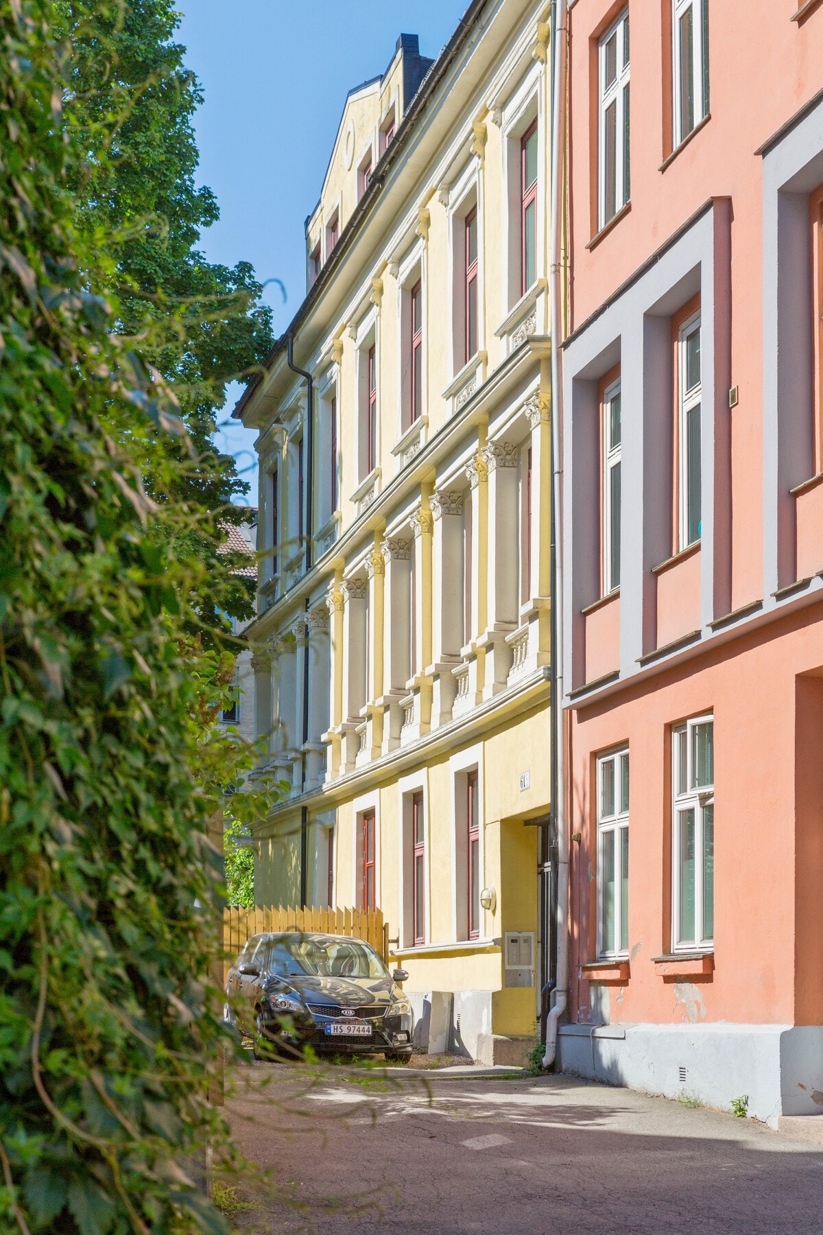 Inngang fra baksiden av gården. Bygget fra 1892 er vernet som kulturminne. Bak andre siden av gaten ligger Botsparken og Klosterenga park. Galleribilde