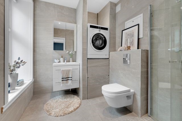 Romslig bad med dusj og vaskemaskin Galleribilde