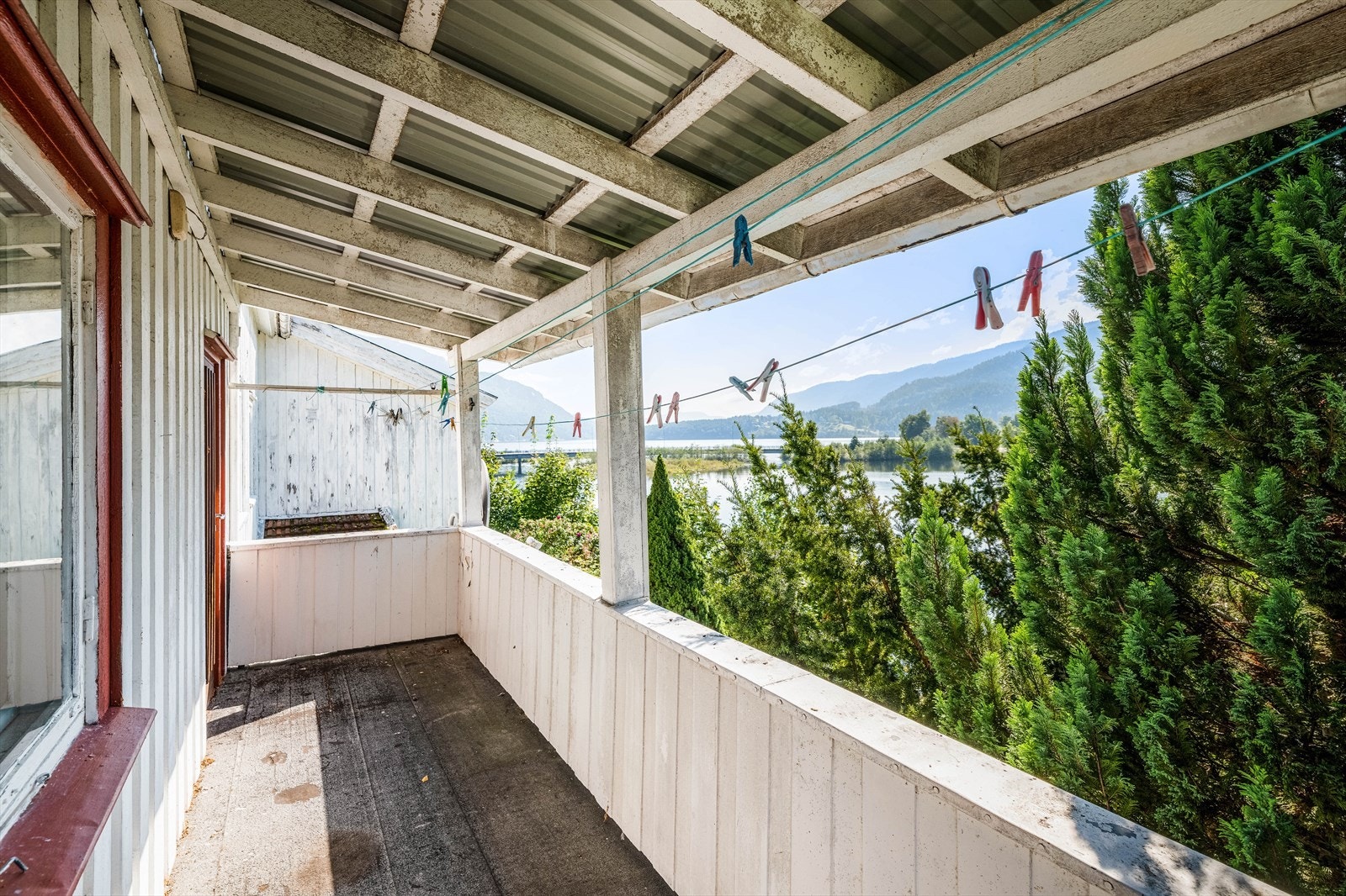 Fra stuen er det utgang til en overbygget veranda hvor det er flott utsikt mot vannet. Galleribilde