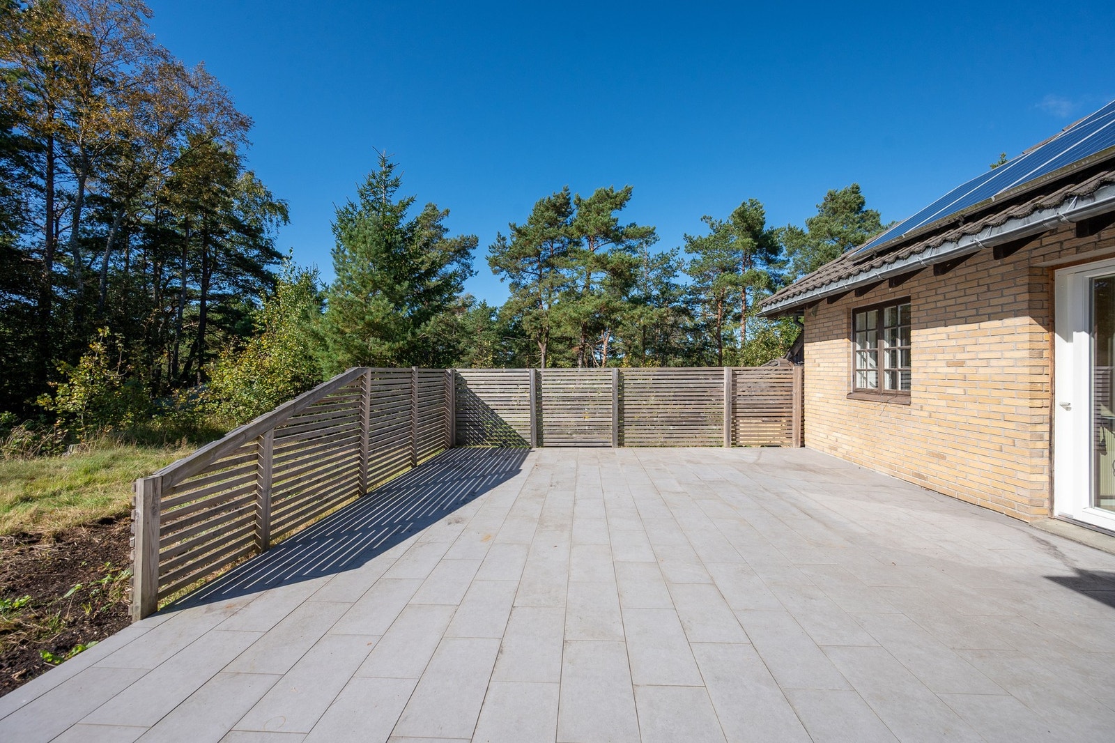 Boligen har en stor flislagt terrasse på ca. 45 kvm mot sydvestvest og en mindre overbygd veranda på ca. 7 kvm mot nordvest. Galleribilde