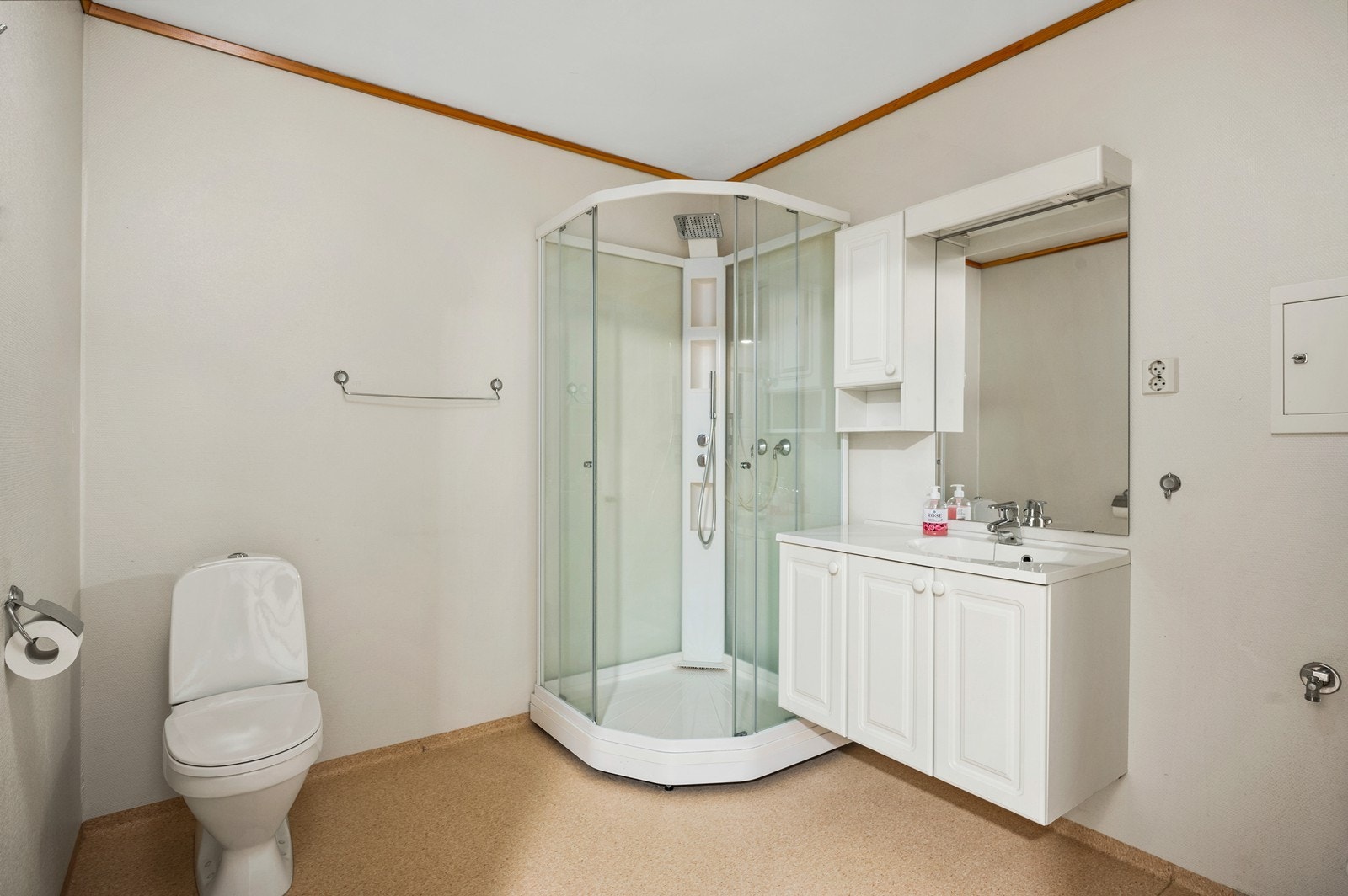 Bad fra byggeår med våtromstapet på vegger og vinylbelegg på gulv. Rommet har innredning med servant, toalett, dusjkabinett og opplegg for vaskemaskin Galleribilde