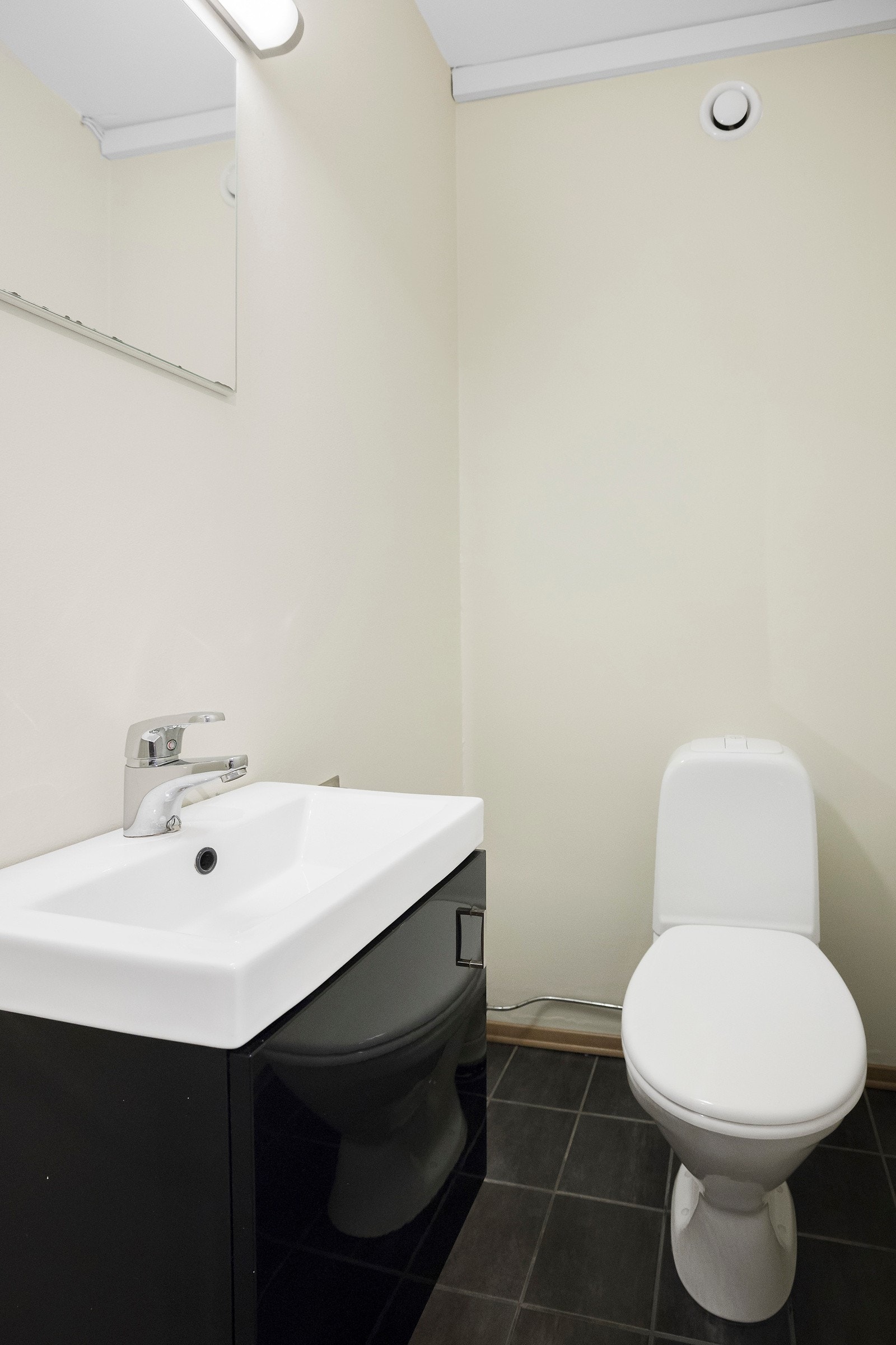 Vegg-i-vegg med badet ligger et toalettrom med moderne servantinnredning. Galleribilde