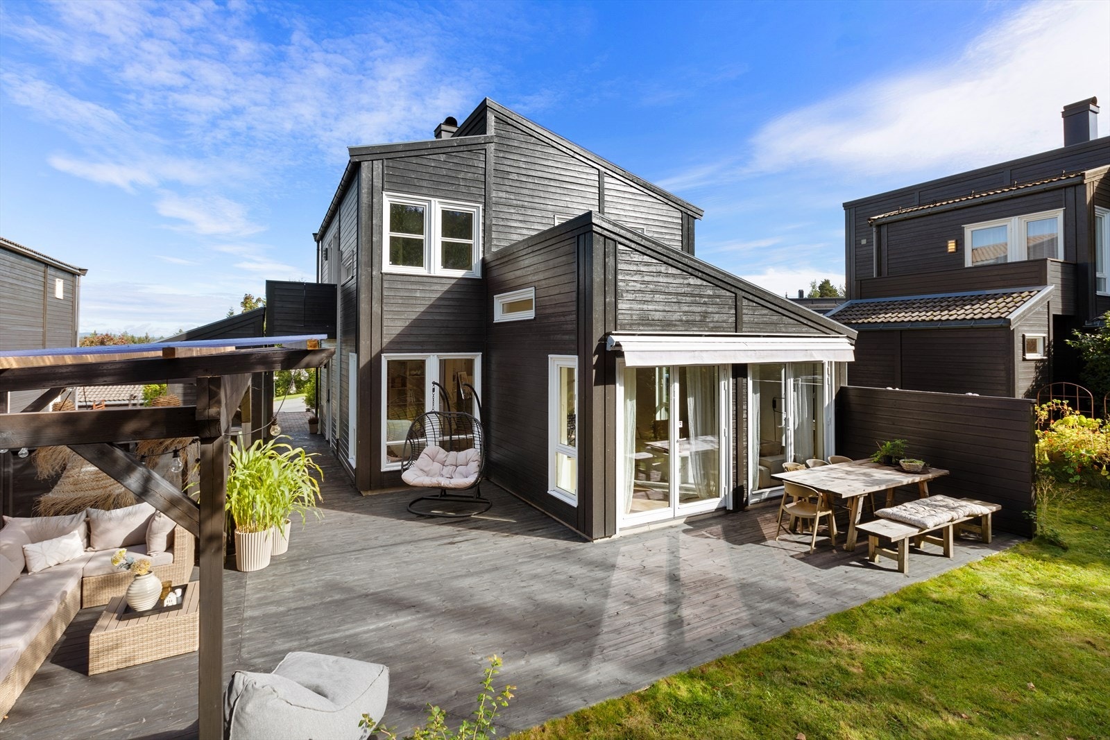 Uteplassen har store terrasseområder med pergola Galleribilde