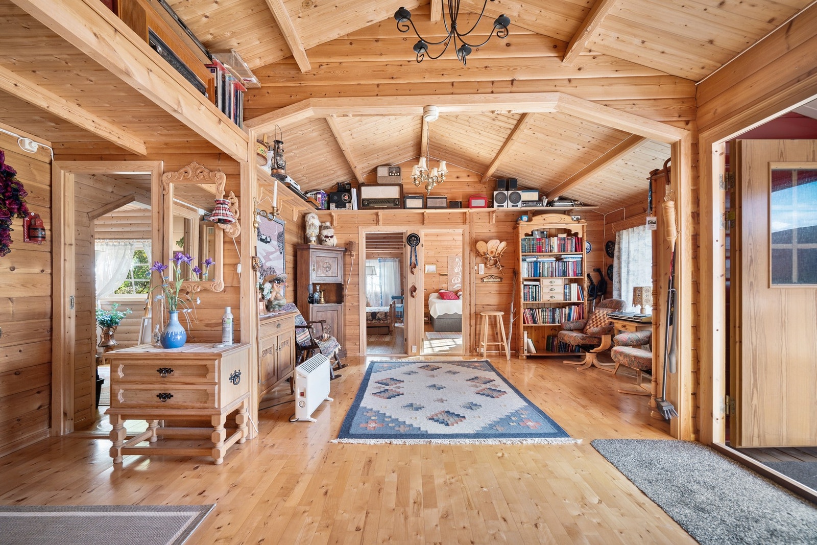 Romslig hall med plass til møblement, innredet med et hyggelig bibliotekhjørne på høyre side Galleribilde