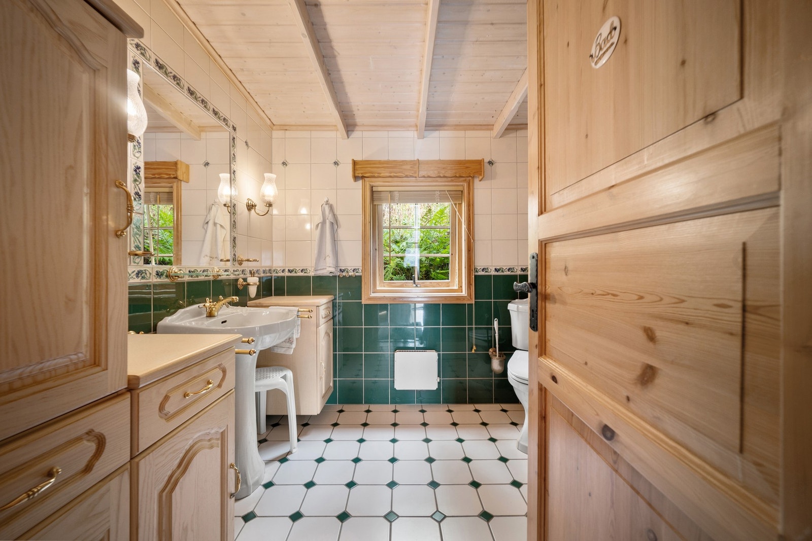 Vegghengt innredning med god oppbevaringsplass, og lys og speil montert i vegg Galleribilde