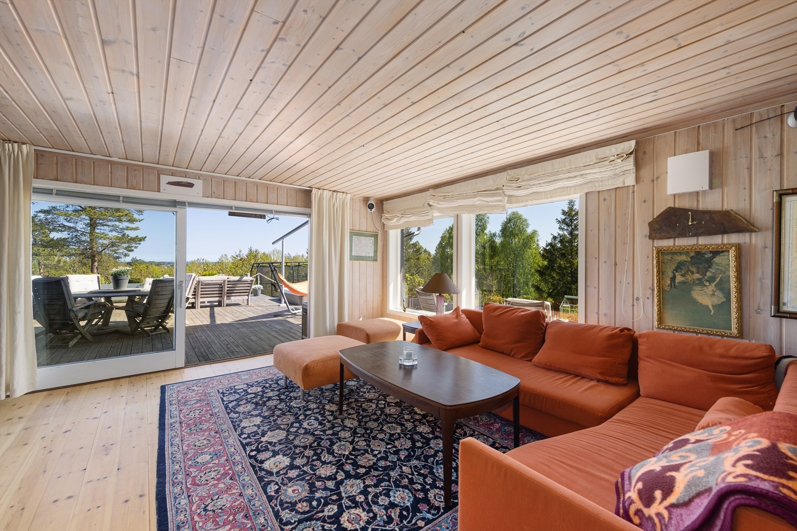 Stuen er romslig og har store vindusflater mot på øst- og sørveggen. En stor skyvedør i glass fører ut en stor terrasse. Galleribilde