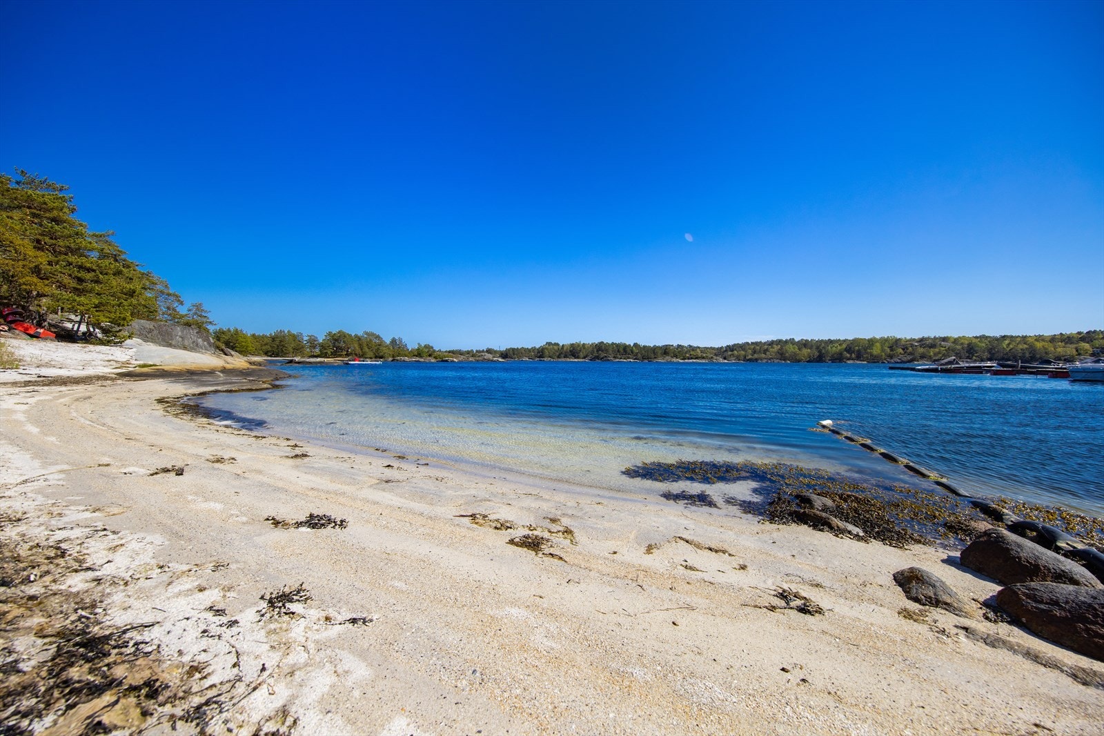 Flott, barnevennlig sandstrand rett ved båtplassene til hytta. Galleribilde