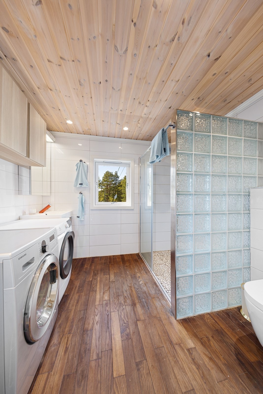 Hyttas andre bad inneholder veggmontert wc, opplegg til vaskemaskin, dusjnisje med to dusjer, servantskap og speilskap. Galleribilde