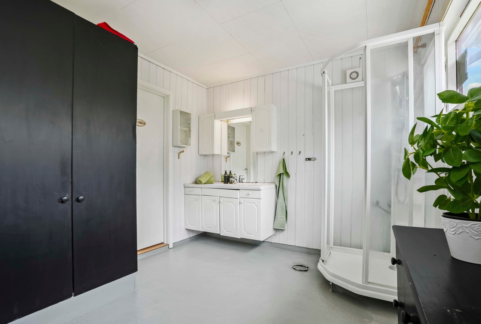 Bad på hovedplan er innreda med klosett, dusjkabinett, baderomsinnredning og skapinnredning Galleribilde