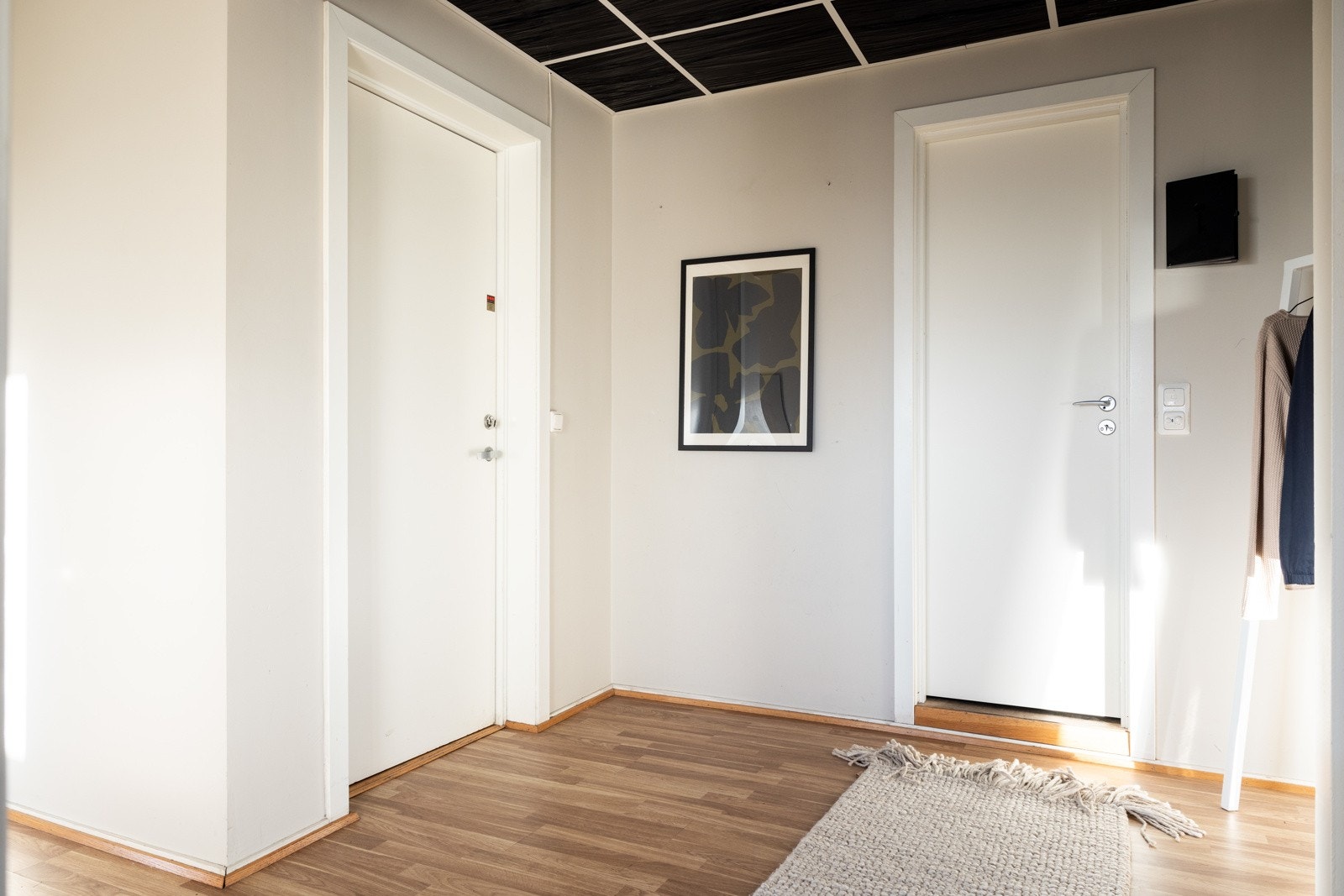 Innbydende entré med parkett på gulv og lyse overflater. Galleribilde