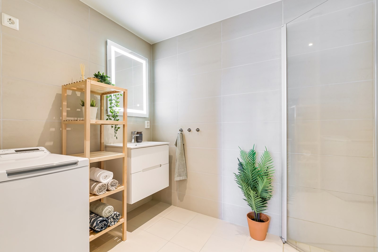 Baderomsinnredningen består av speil med lys, servantskap, dusjsone, toalett og opplegg for vaskemaskin Galleribilde