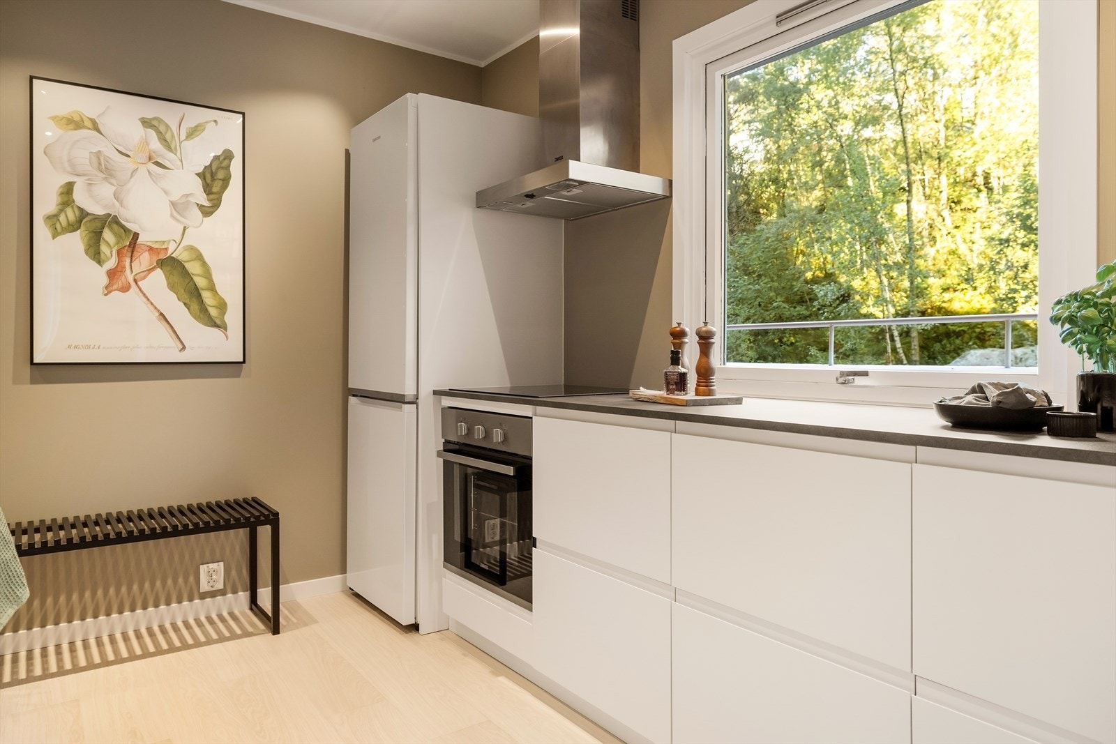 Gulvet har 1-stavs laminat, som harmonerer med de slette malte veggene og himlingen, og gir en helhetlig og moderne følelse. Galleribilde