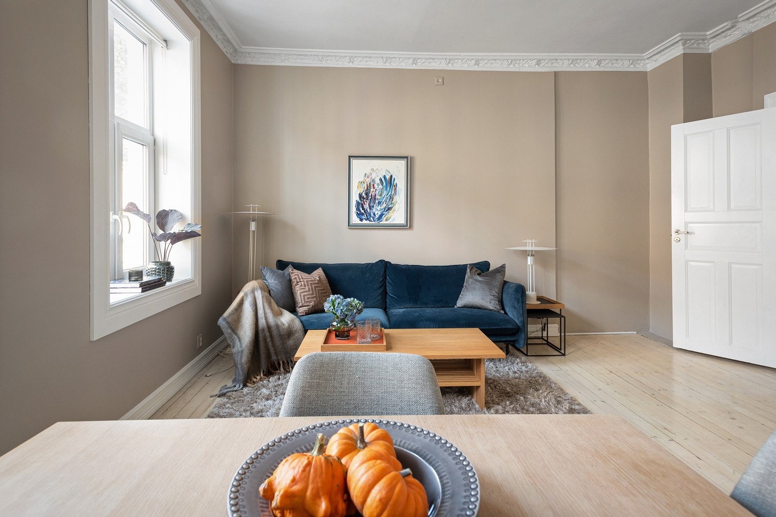 Åpen stue/kjøkkenløsning med plass til sofa, sofabord og tilhørende møblement Galleribilde