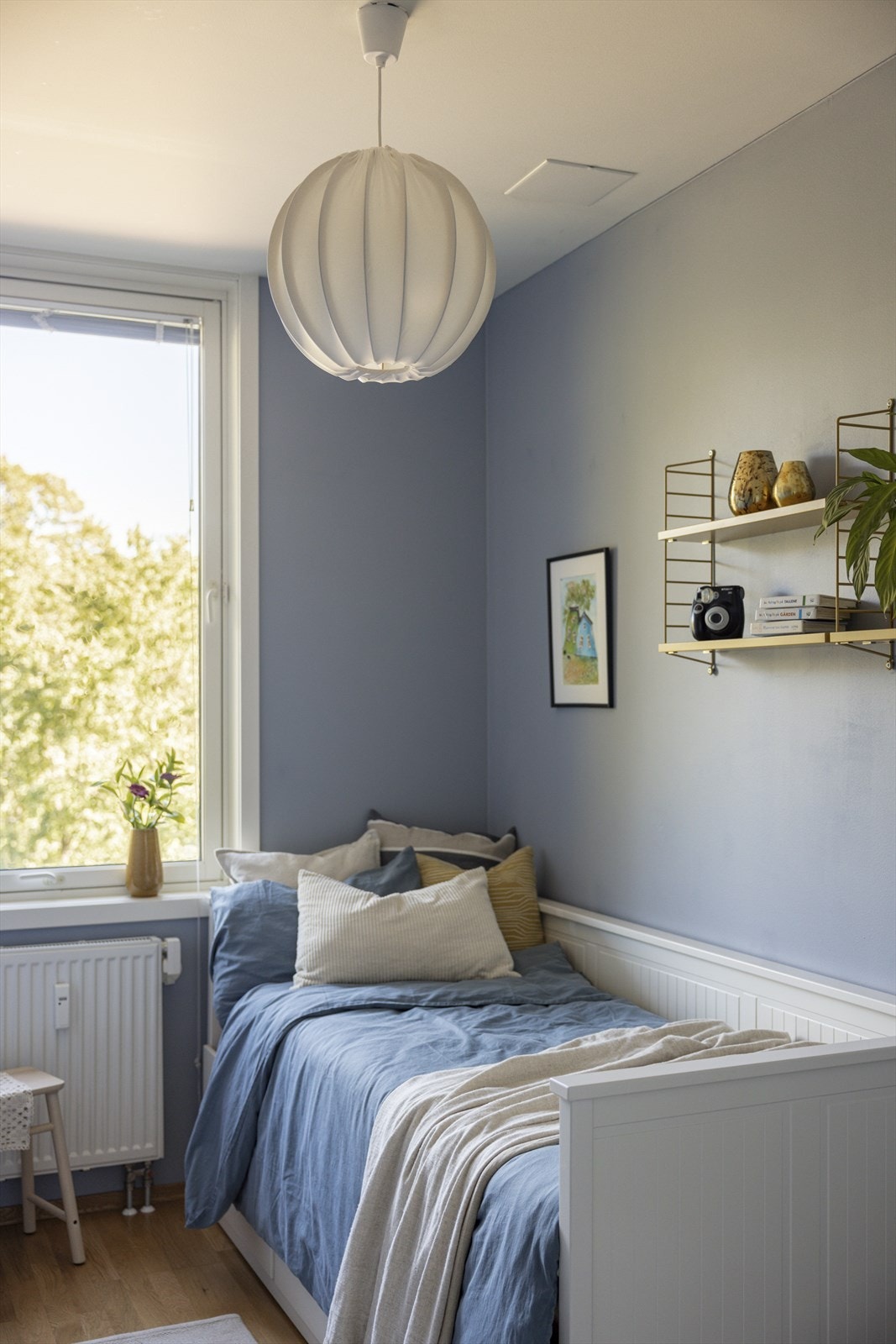 Rommet er malt lyseblått og får godt med lys inn gjennom vindu. Galleribilde