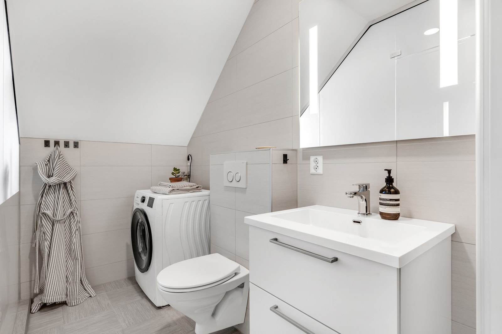 Lyst baderom som er fra 2016, og har opplegg for vaskemaskin. Galleribilde