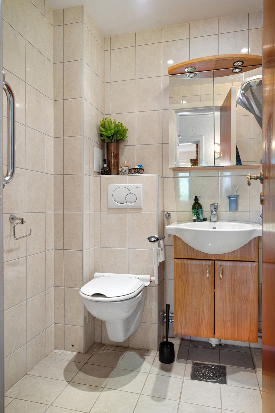 Flislagt bad med varmekabler renovert i regi av borettslaget i 2008. Badet er utstyrt med servant, servantskap og veggmontert wc Galleribilde