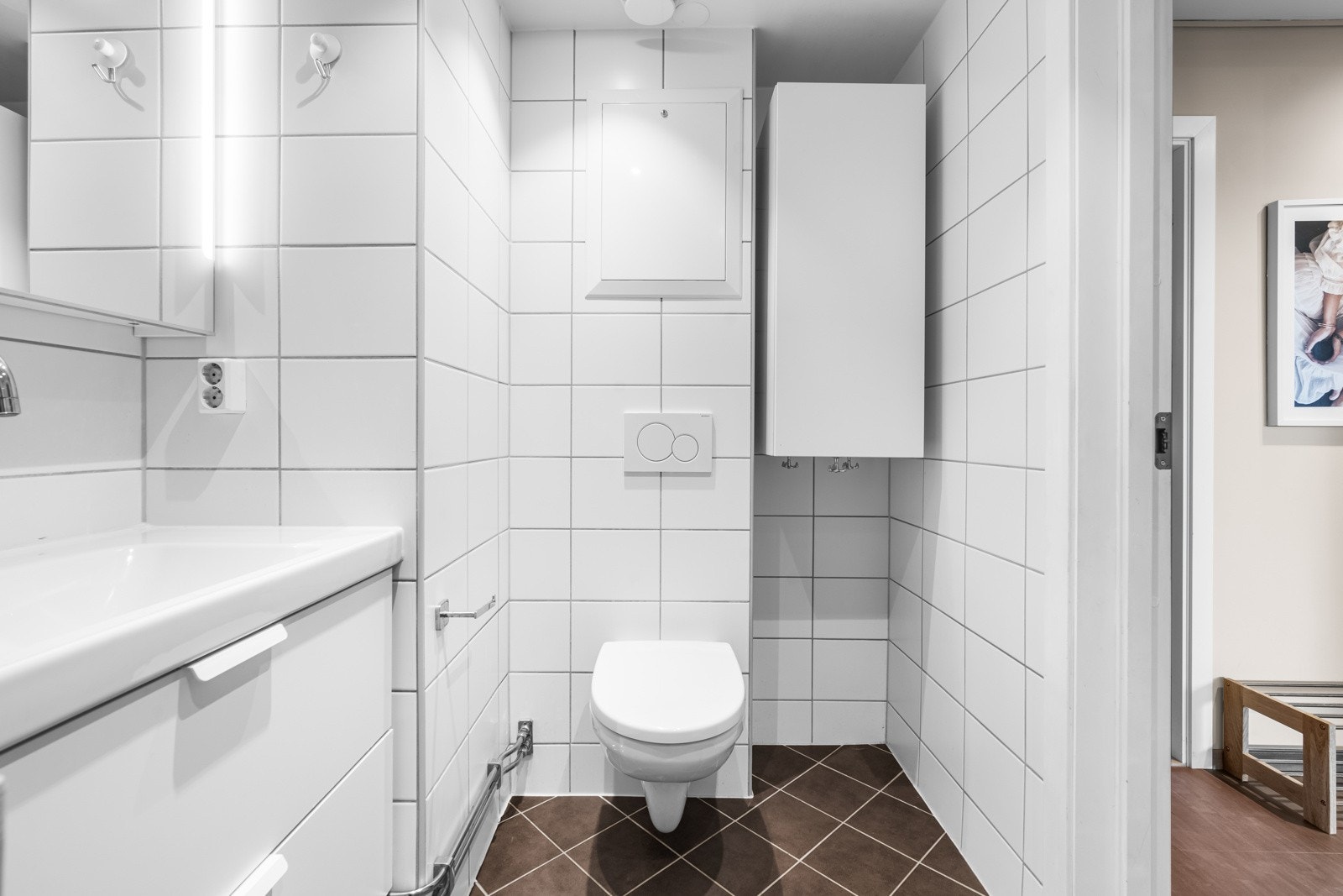 Baderommet har flislagte vegger og hvitmalt himling med downlights, videre er det flislagt gulv med termostatstyrte varmekabler Galleribilde