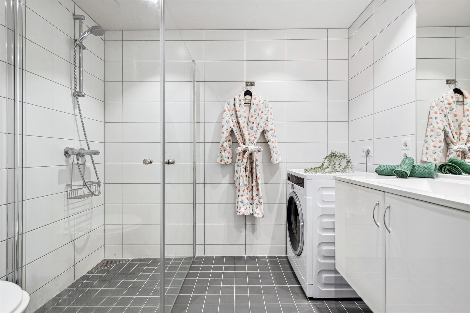 Flislagt baderom med opplegg for vaskemaskin. Galleribilde