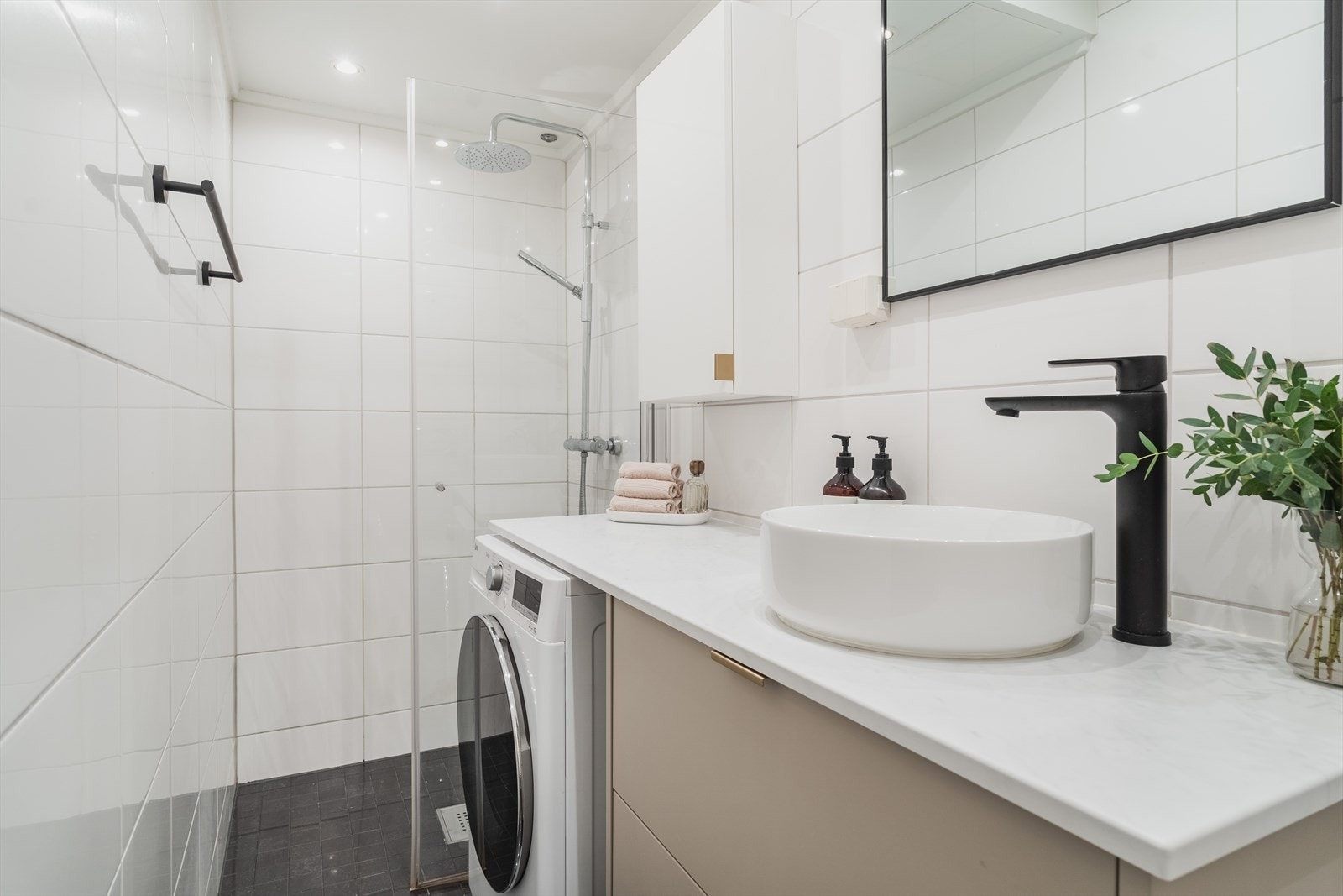 Pent baderom med flislagte overflater, varme i gulv og opplegg for vaskemaskin Galleribilde