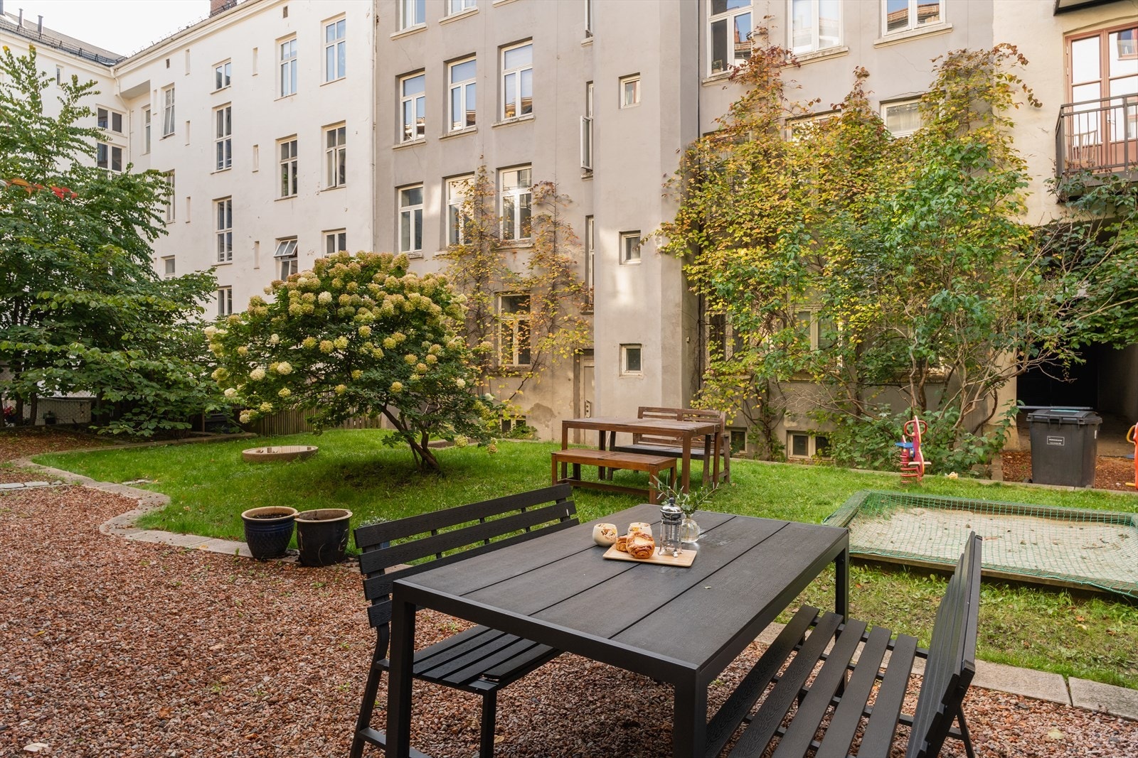 Bakgården er pent opparbeidet med sittebenker og flotte grøntområder Galleribilde