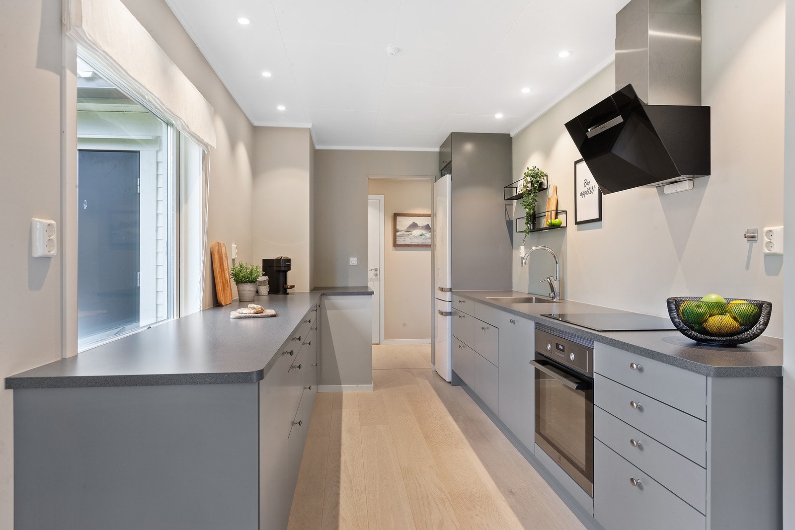 Lekkert kjøkken med integrert oppvaskmaskin, platetopp og stekovn. Galleribilde