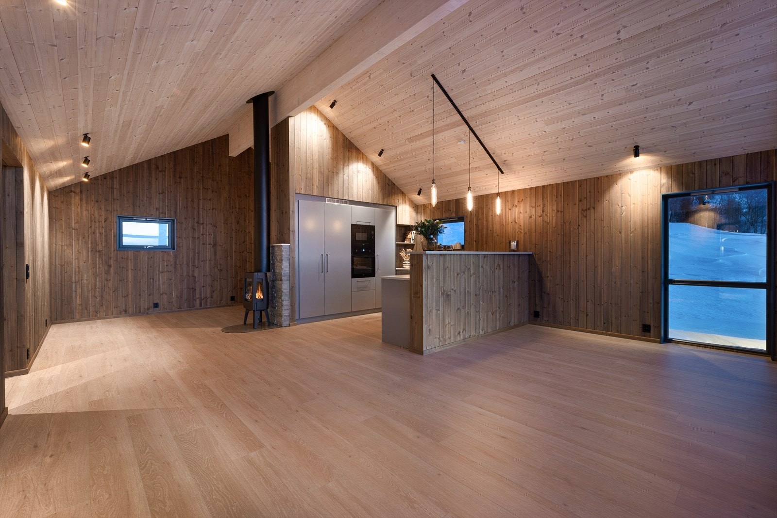 Fra entreen kommer man inn i et herlig allrom med et stilrent kjøkken mellom to stuer. Galleribilde